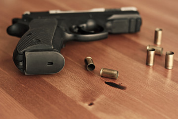 Hand gun on a table with ammo