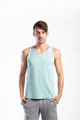 Obraz premium Handsome fitness man in blue tank top shirt, studio shot.