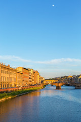 Arno River in Florence in the evening light and the full moon in the sky