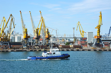 Fototapeta na wymiar Tugboat and port cargo crane
