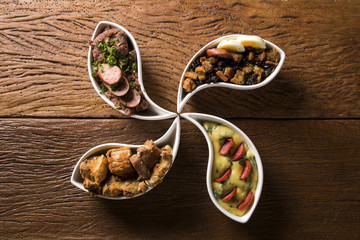 Four typical dishes of the Brazilian cuisine called tropeiro beans, torresmo, polenta and tutu of beans