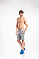 Fototapeta premium Shirtless fitness man, hand in pocket. Studio shot.