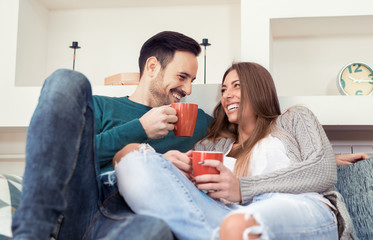 Cute young couple drinking coffee at home - Powered by Adobe