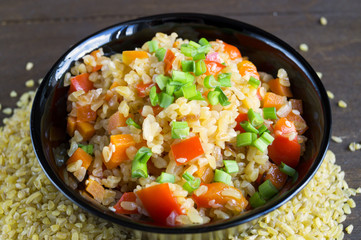 bulgur with vegetables on wooden background