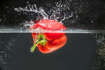 red bell pepper splashing in water