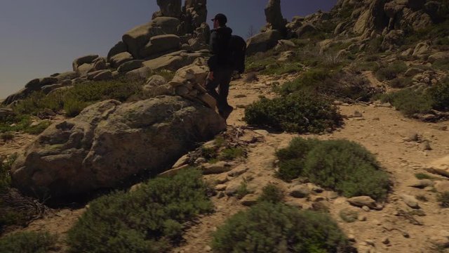 Tracking shot of man hiking in the mountains
