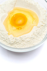 Flour with egg in glass bowl