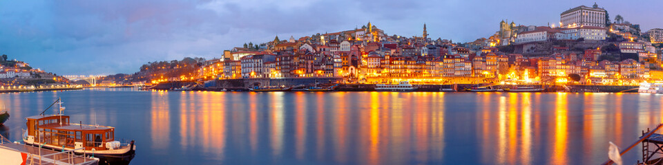 Fototapeta na wymiar Ribeira and Old town of Porto with mirror reflections in the Douro River during evening blue hour, Portugal, Portugal.