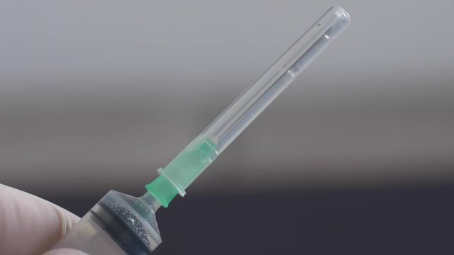 Close up of Medical hand putting the cap on hypodermic needle