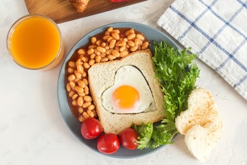 Breakfast - toast, Omelette heart, Bean, tomatoes cherry and salad served with hot coffee and orange juice.