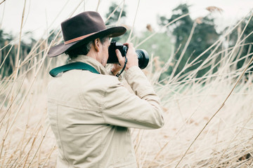 Obraz premium Rear view of man with hat photographing nature.