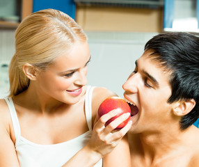 Couple playfully eating apple