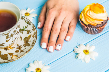 Still life with cup of tea and cake on the wooden background