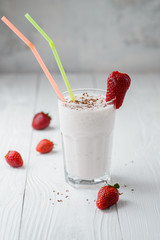 strawberry milkshake with chocolate on a white wood background. selective focus