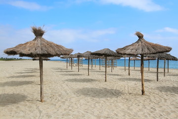 Parasols à la plage/ Parasols en paille  à la plage sous un beau ciel bleu avec sable fin blanc