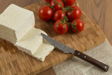 organic cheese and tomatoes on wooden cutting board