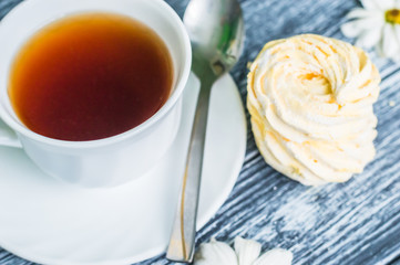 Still life with cup of tea and cake on the wooden background