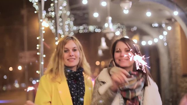 young women with sparklers on the background of night city