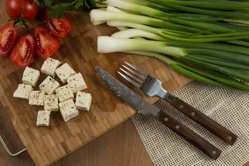 organic cheese and tomatoes on wooden cutting board
