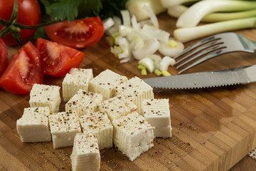 organic cheese and tomatoes on wooden cutting board