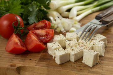 organic cheese and tomatoes on wooden cutting board