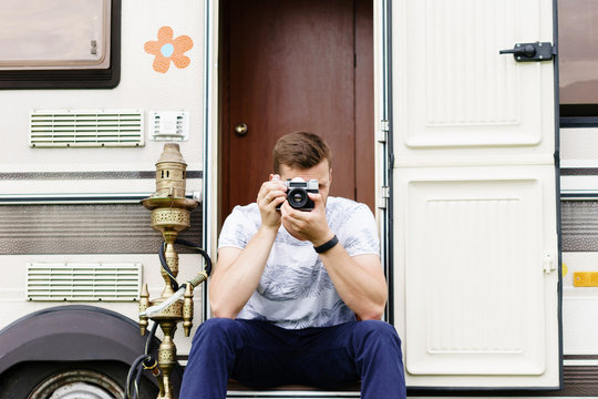 Young, handsome hipster taking pictures outdoors. Holiday, journey, vacation concept.