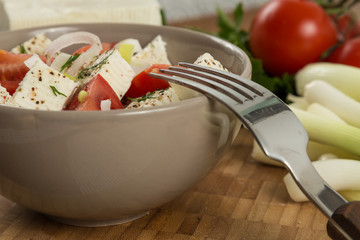 organic cheese and tomatoes salad on wooden table close up