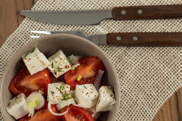 organic cheese and tomatoes salad on wooden table top view