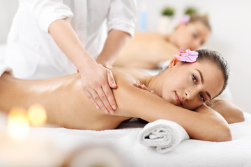 Obraz na płótnie Canvas Two beautiful women getting massage in spa
