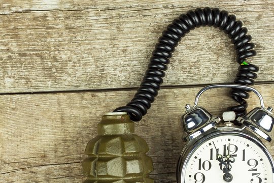 Grenade and old alarm clock. Timed bomb. The concept of terrorism.
