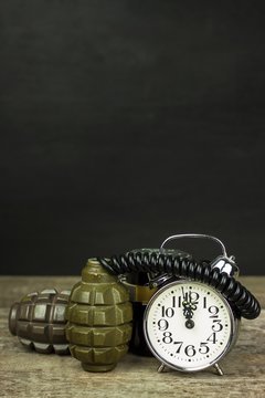 Grenade and old alarm clock. Timed bomb. The concept of terrorism.
