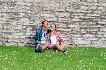 Young and happy couple chilling in park. Love, relationship, romance concept.