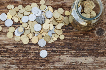 Ukrainian coins in glass jar on a wooden background