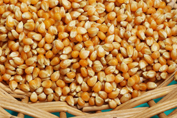 Popcorn kernels in basket, background.