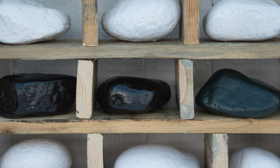 Black and white stones on rustic shelving