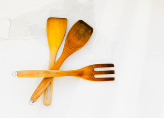 top view of wooden kitchen utensils on white cracked floor
