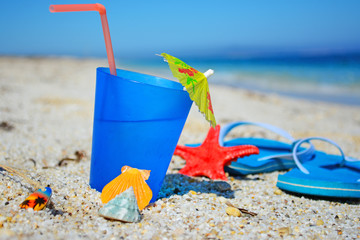 drink and flip flops on the sand