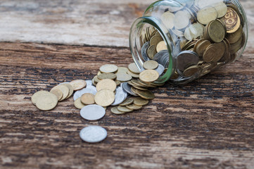 Ukrainian coins in a jar on a wooden background
