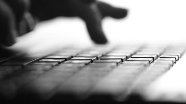 Silhouette video of female hands typing by fingers on netbook keyboard entering a request on the Internet, communicating in social networks, ordering services, working in the office