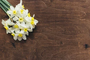 Foto op Canvas .Daffodils lie on a wooden background © Денис Кипкаев