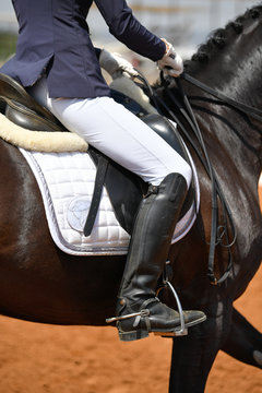 Close up on a bay horse with rider during a dressage competition