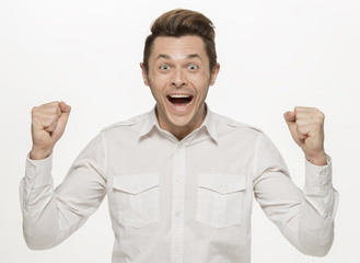 Fototapeta premium Handsome young man winning and celebrating, isolated on white
