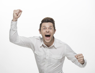 Fototapeta premium Handsome young man winning and celebrating, isolated on white