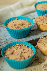 Chocolate muffin with soft cream and fresh blueberry powdered with sugar, cup of coffee, rustic background