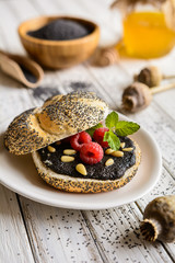 Roll with poppy seed spread, raspberry and pine seeds