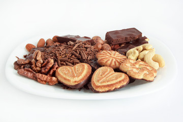 Nuts and confection lying at the white plate.