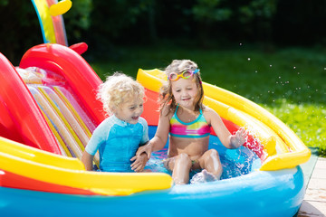 Kids in garden swimming pool with slide