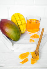Mango on a white wooden background with juice