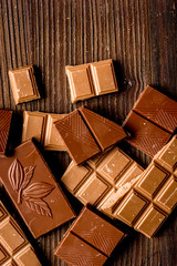 chopped chocolate pieces for dessert wooden desk background top view