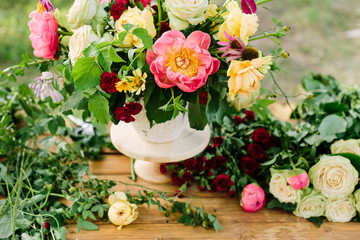 Fototapeta na wymiar bouquet, holiday flower, gift and floral arrangement concept - beautiful bouquet of yellow and white roses, pink peonies, daisies and carnations, white vase on wooden table, around flowers and plants